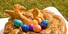Gebackener Eierring, mit Mandeln, in der Ringmitte gefärbte Ostereier und Hefegebäck in Hasenform