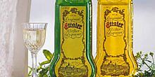 Zwei Flaschen Ettaler Klosterlikör, grüne und gelbe Farbe, daneben gefülltes Likörglas