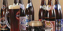 Zwei gefüllte Bierkrüge vor mehreren Flaschen Hofer Bier, verschiedene Brauereien