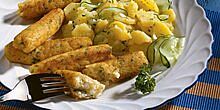 Mehrere Fischwürste angerichtet auf Teller, mit Kartoffelsalat, Gurkenscheiben und Petersilie, Gabel